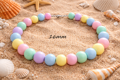 Colorful beaded necklace on sand with shells in the background