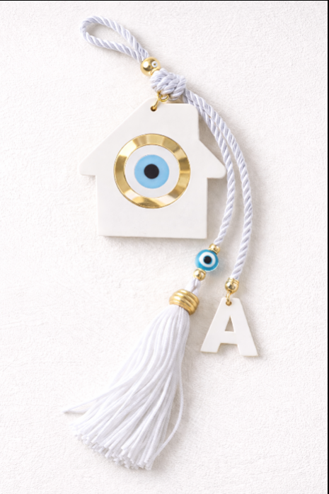 Personalized white plexiglass house wall hanging featuring a blue Greek evil eye, a custom initial charm, and a white tassel on a decorative cord.