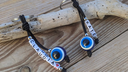 Personalized Greek evil eye keychain attached to keys, custom name keyring for everyday use and protection.