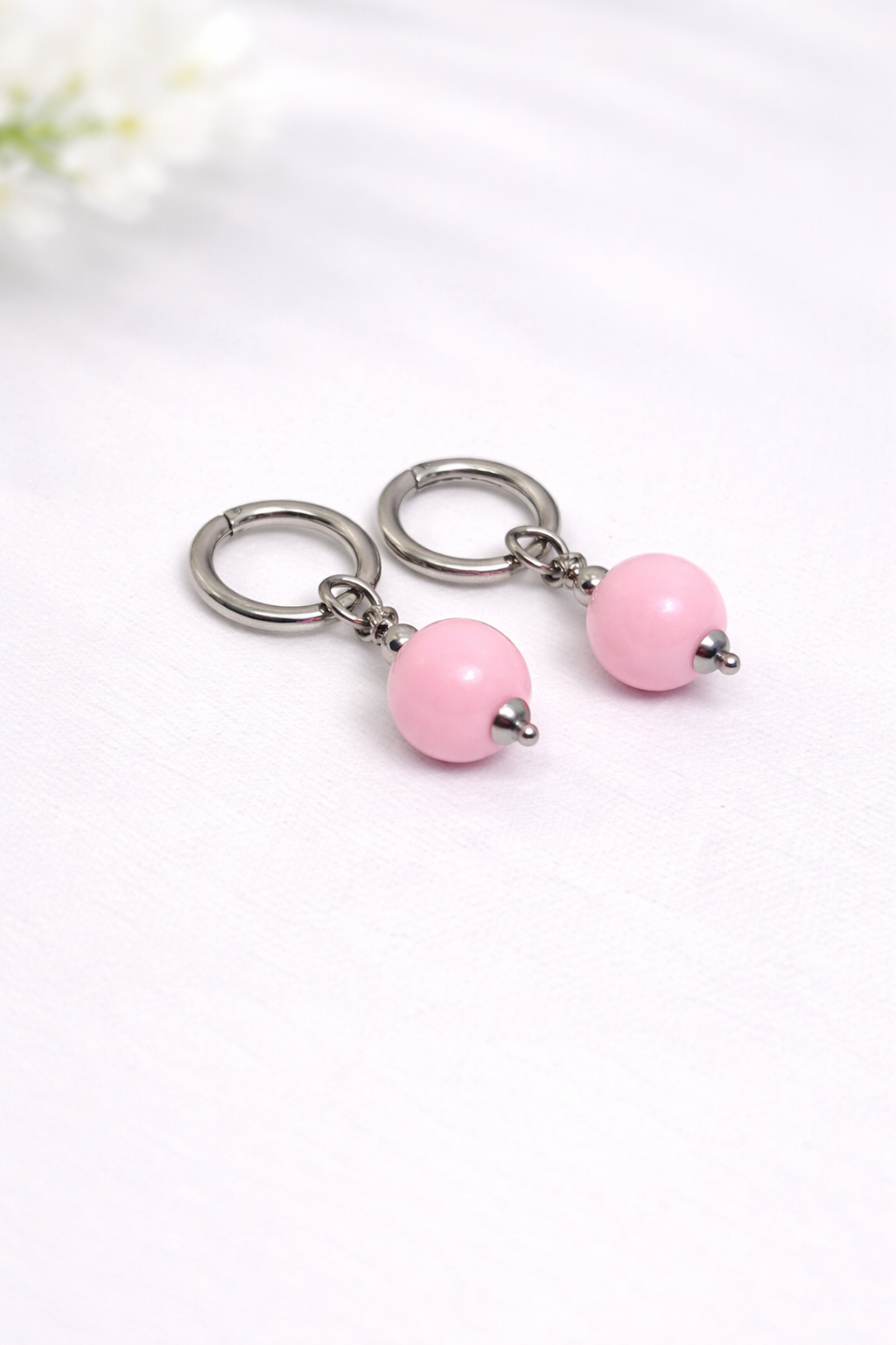 Pair of earrings with pink beads on a white background