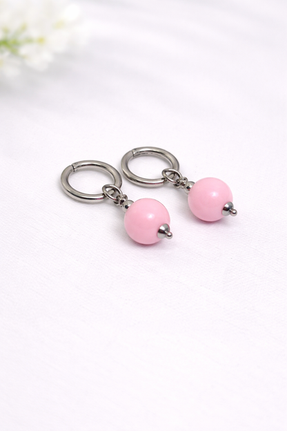 Pair of earrings with pink beads on a white background