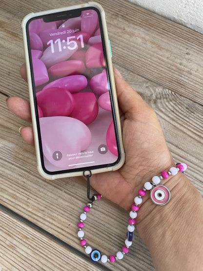 Hand holding a smartphone with a colorful case on a wooden surface