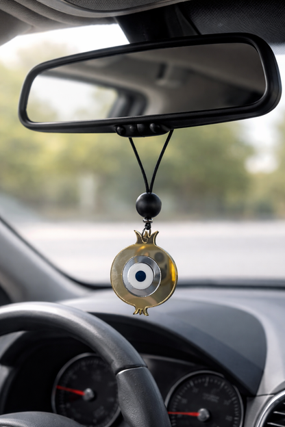 Car dashboard with an evil eye hanging ornament
