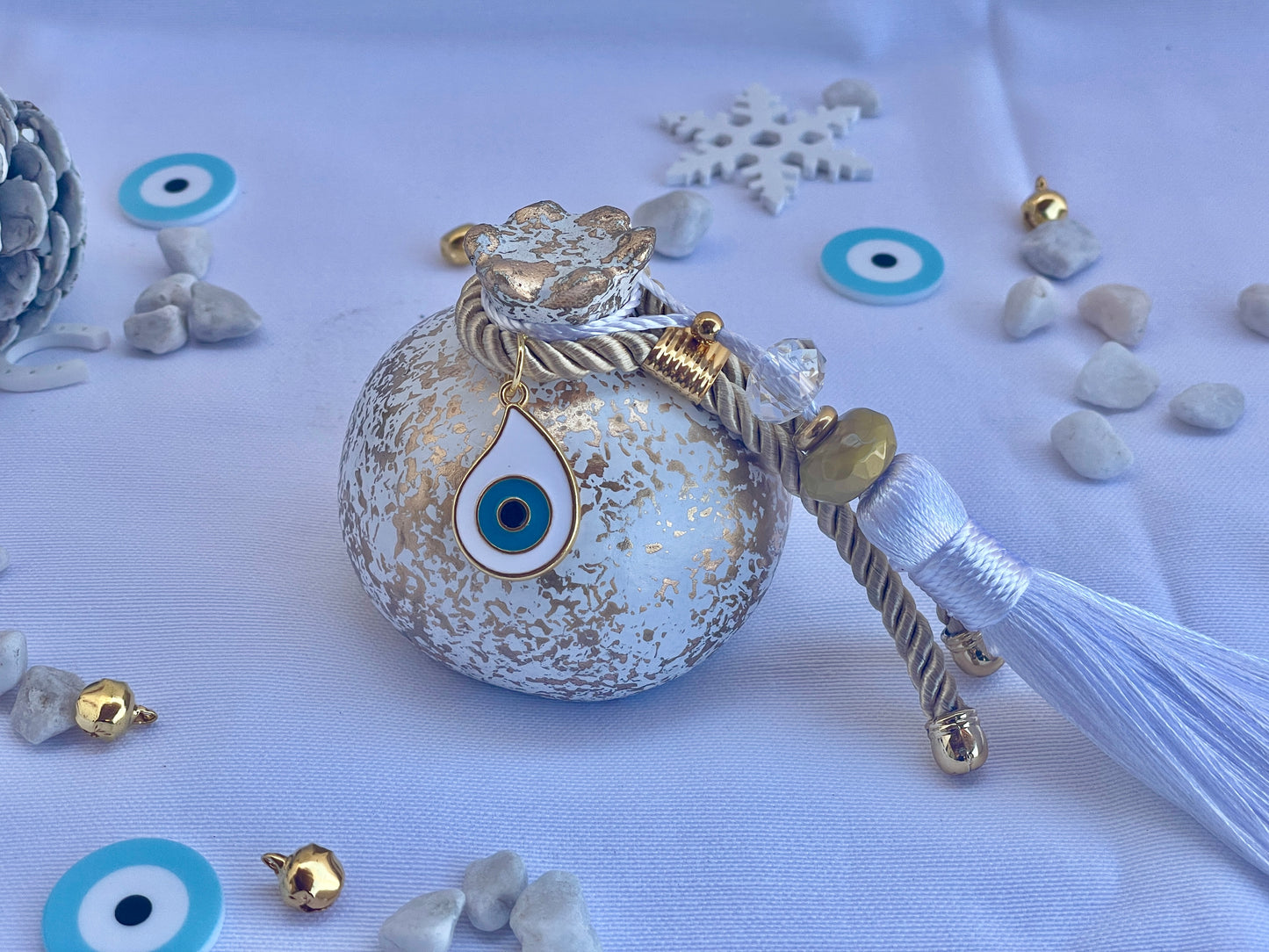 Decorative pomegranate with evil eye pendant with tassel on a white background