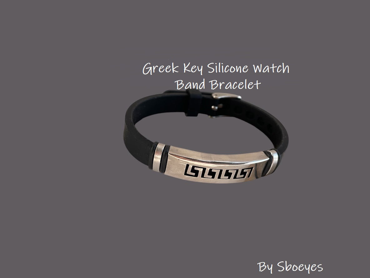 Black silicone watch band with metallic Greek key design on a gray background