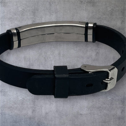 Black leather belt with silver buckle on a gray background