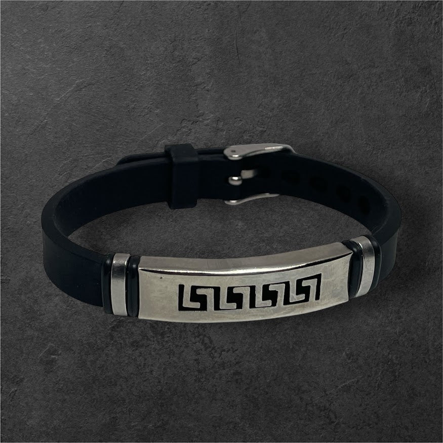 Black leather bracelet with metallic clasp and engraved design on a dark gray background