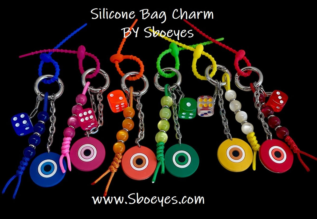 A collection of colorful silicone evil eye bag charms with beaded chains, displayed in a variety of colors.
