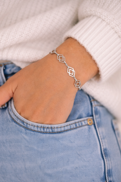 Silver bracelet on a wrist with a blurred background