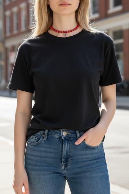 Person wearing a black t-shirt and blue jeans with a blurred urban background