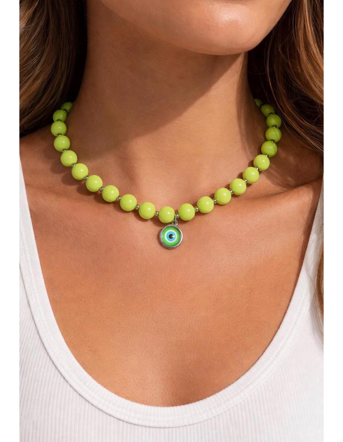 Necklace with a green bead and eye charm worn by a person