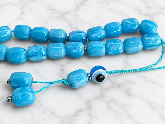 Handmade Greek komboloi featuring marbled turquoise acrylic beads, a blue evil eye bead, and a matching turquoise cord.