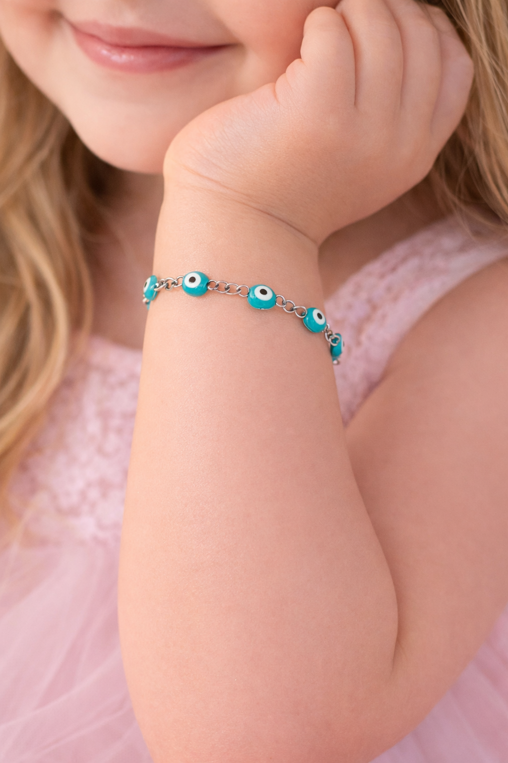 Child's arm wearing a bracelet with turquoise beads