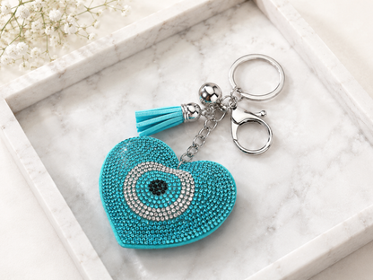 Turquoise heart-shaped keychain with tassel on a marble surface