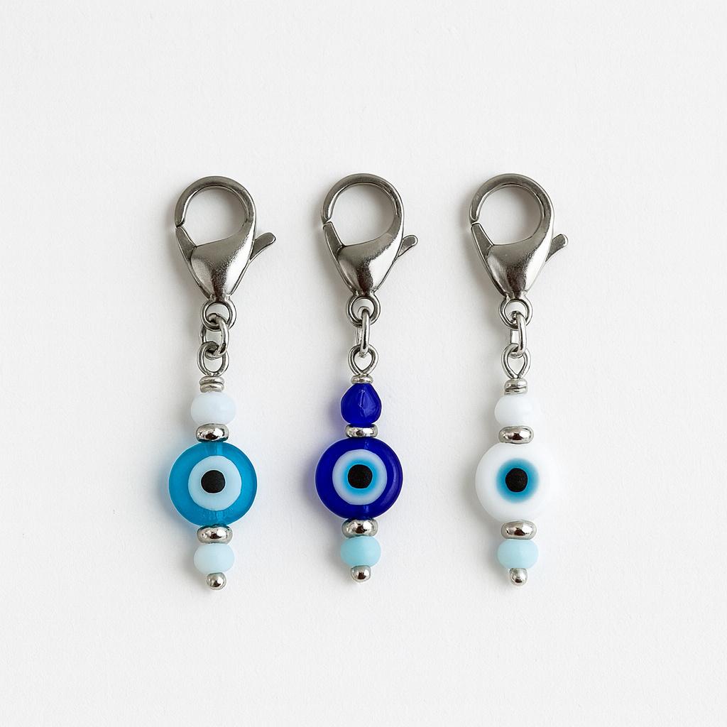 Three evil eye keychain charms with blue and white beads on a white background