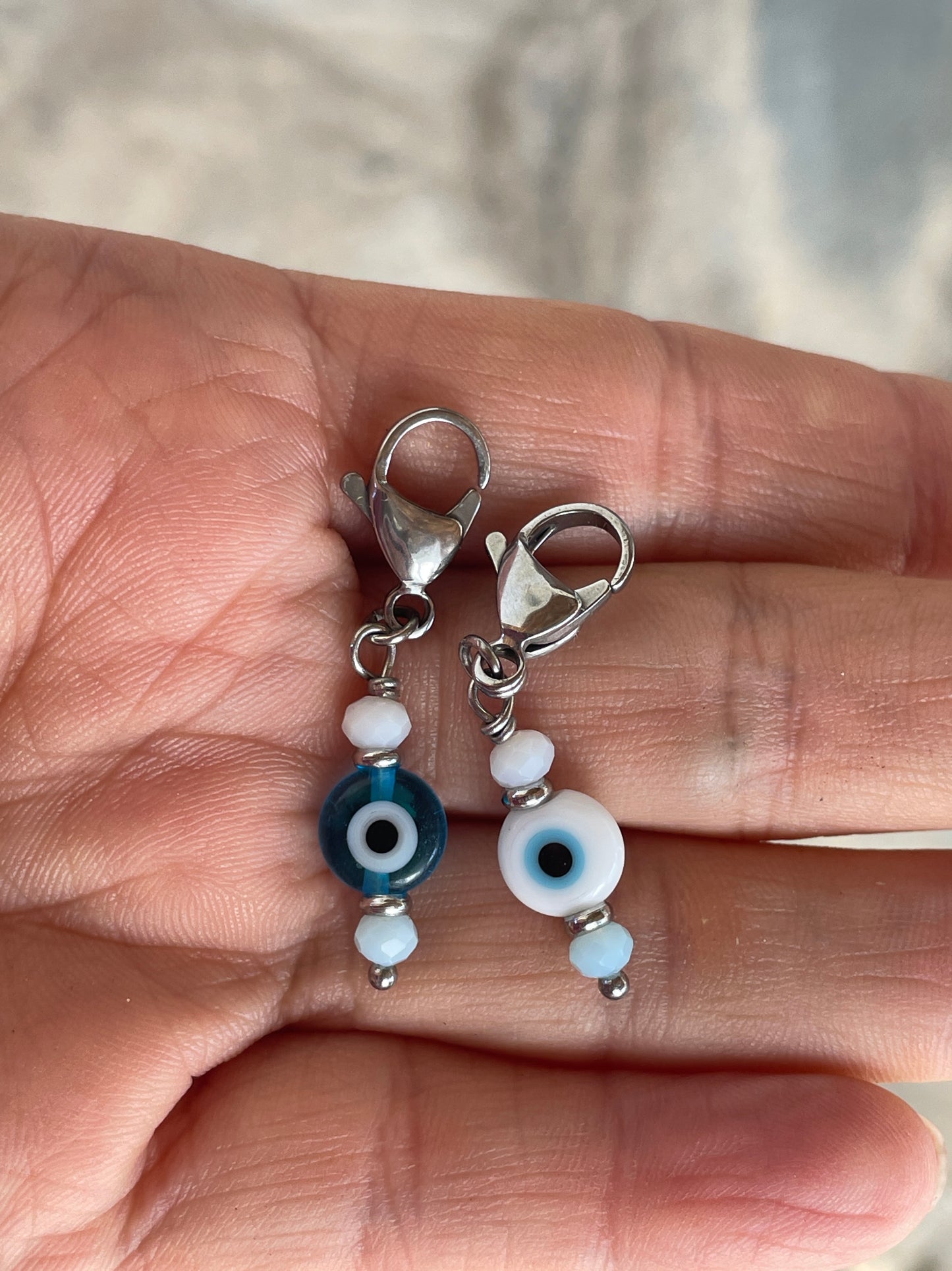 Small charm with beads on a hand against a blurred background