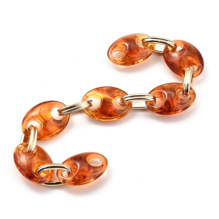 Orange chain bracelet with gold accents on a white background