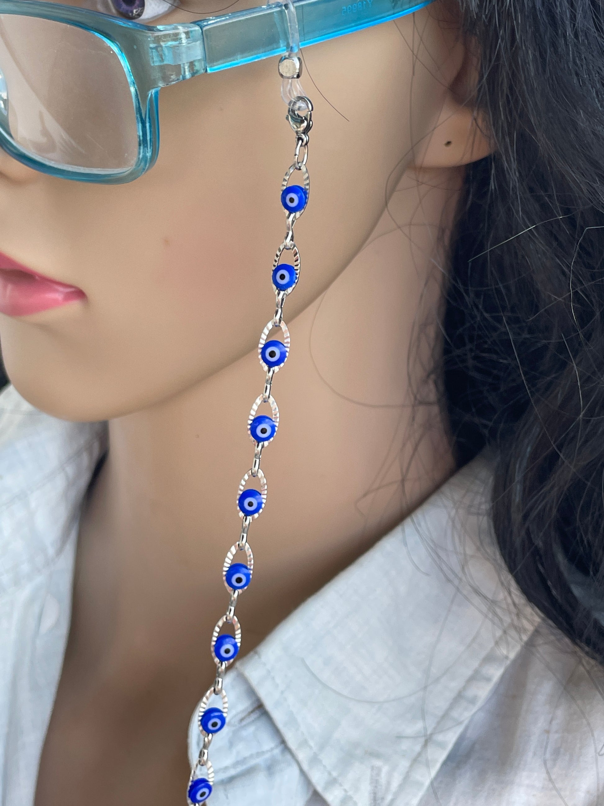 Close-up of a person wearing a blue beaded anklet on a light-colored surface.