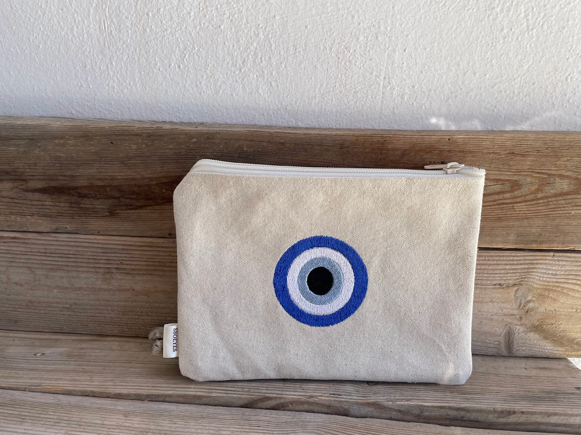 Beige pouch with a blue and white circular design on a wooden surface