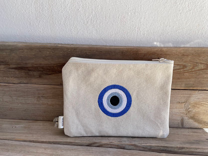 Beige pouch with a blue and white circular design on a wooden surface