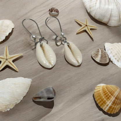 Shell earrings with starfish and seashells on a wooden surface