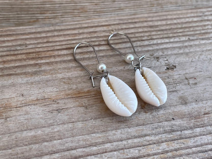 Shell earrings on a wooden surface