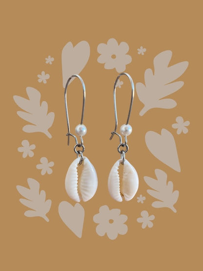 Shell earrings with pearls on a decorative brown background
