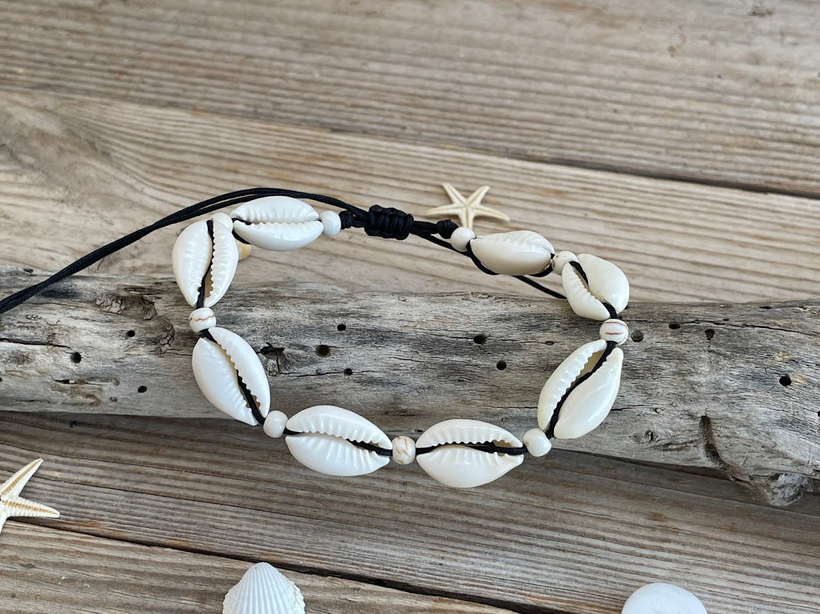 Necklace with cowrie shells on a wooden surface