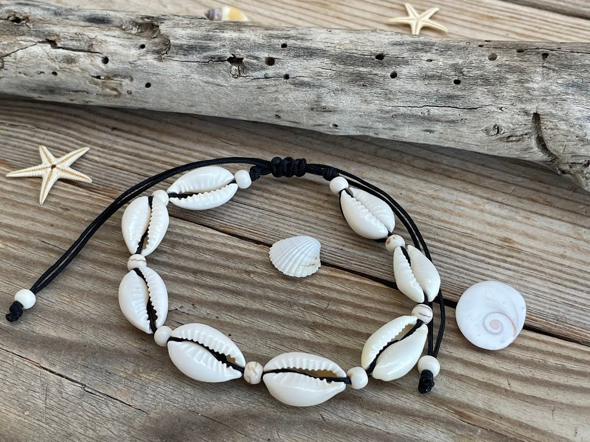 Necklace with shell beads on a wooden surface with starfish
