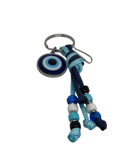 Keychain with blue and black beads and an evil eye design on a white background