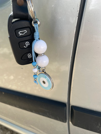 Keychain with beads attached to a car key fob on a vehicle door