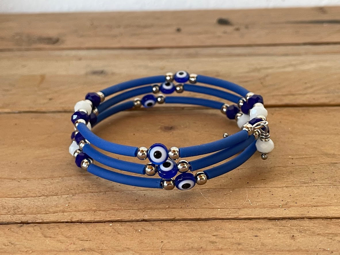 Blue bracelet with evil eye beads on a wooden surface
