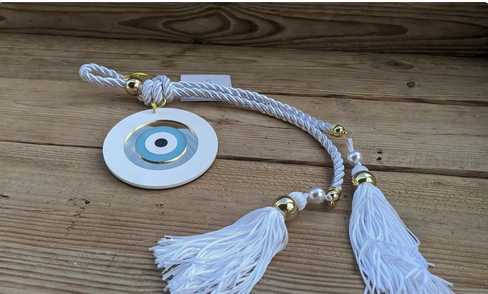 Decorative hanging with tassels and a circular design on a wooden surface