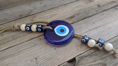Glass evil eye wall hanging on the wooden table