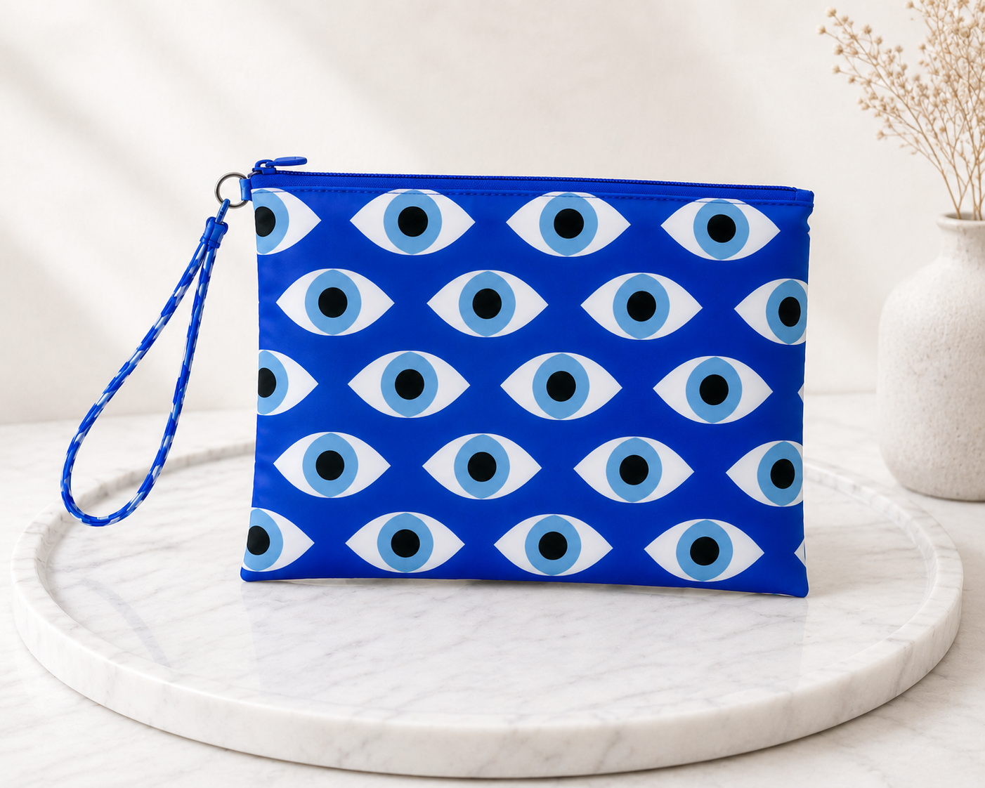Handmade blue evil eye pouch with Greek mati pattern on a marble surface.