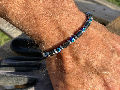 Close-up of a wrist wearing a beaded bracelet with blue eye beads.