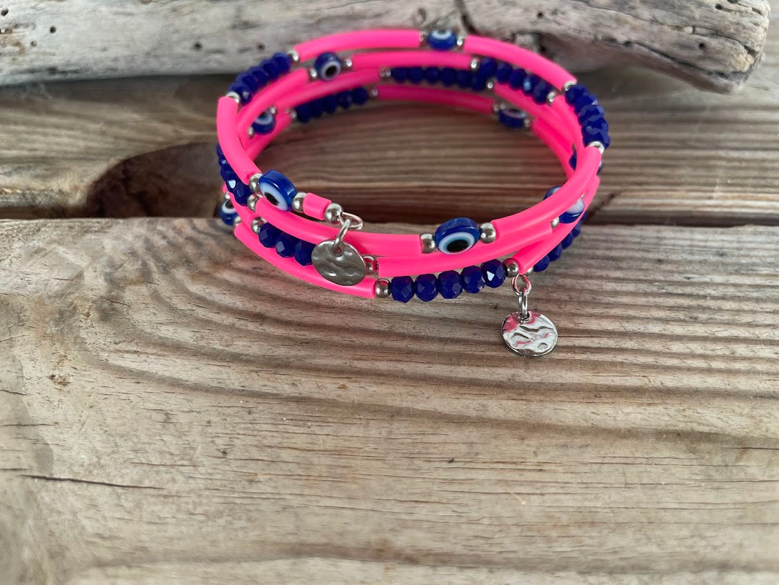 Pink and blue beaded bracelet with charms on a wooden surface