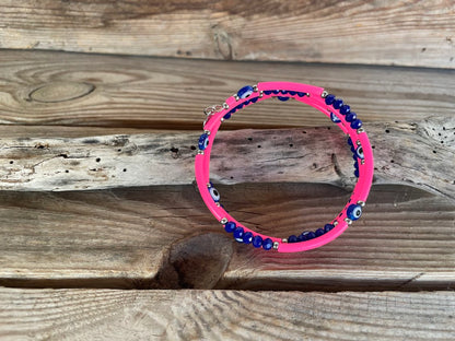 Pink bracelet with blue beads on a wooden surface