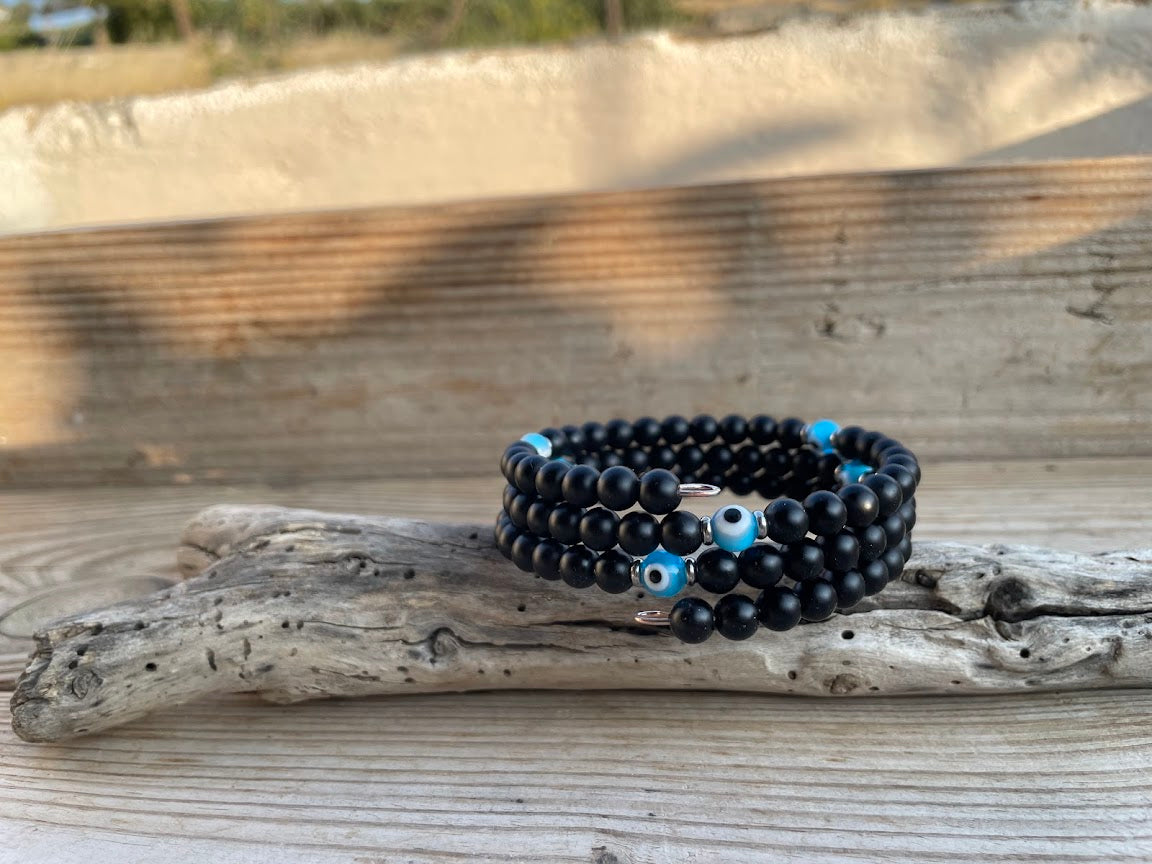 Black beaded bracelet with blue accents on a wooden surface