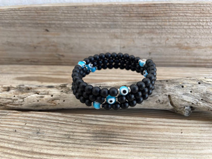 Black beaded bracelet with blue accents on a wooden surface