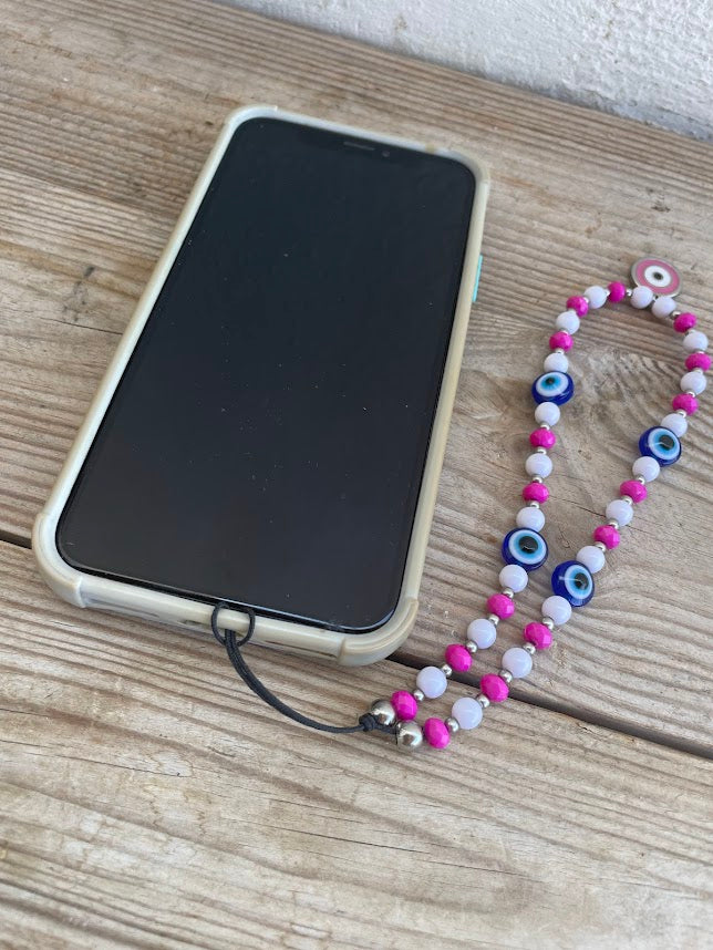 Phone with a case and a colorful beaded necklace on a wooden surface