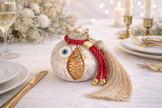 Decorative bottle with tassel on a festive table setting with candles and plates.