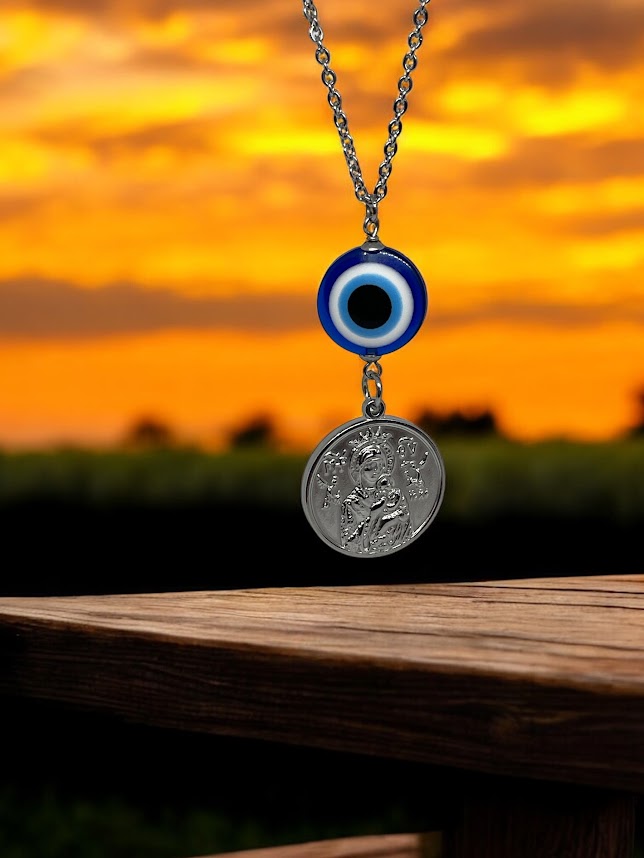 Necklace with an evil eye pendant and a coin charm against a sunset background