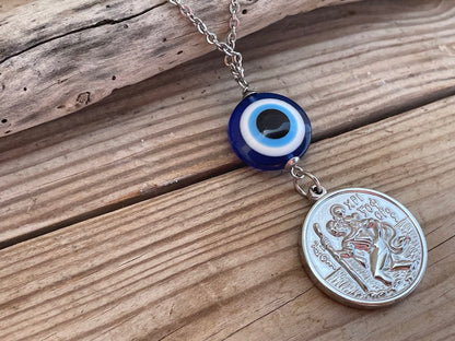 Necklace with an evil eye charm and a coin pendant on a wooden surface