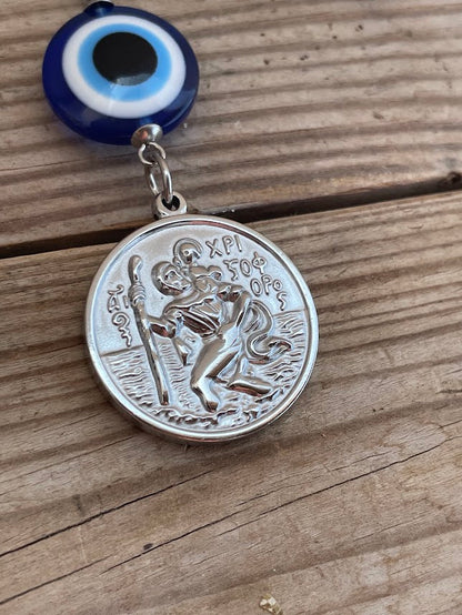 Silver medallion with religious design on a wooden surface