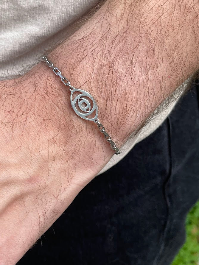 Silver bracelet with a spiral design on a wrist.