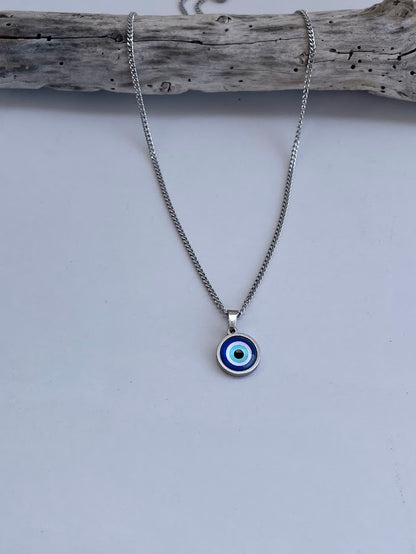 Silver necklace with a blue and white eye pendant on a white background.