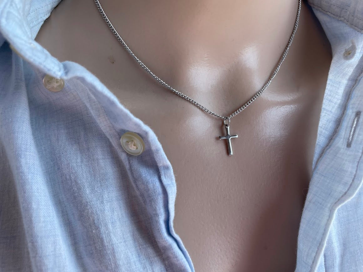 Mannequin wearing a silver necklace with a cross pendant