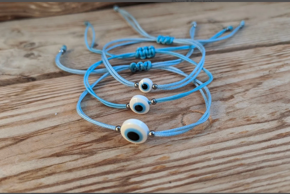 Blue bracelets with eye charms on a wooden surface