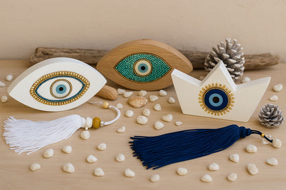 Decorative items including eye-shaped objects and tassels on a wooden surface with pebbles.